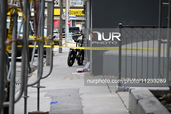 An investigator is placing evidence markers at the scene of a slashing attack where they have found evidence and blood on the ground. Police...