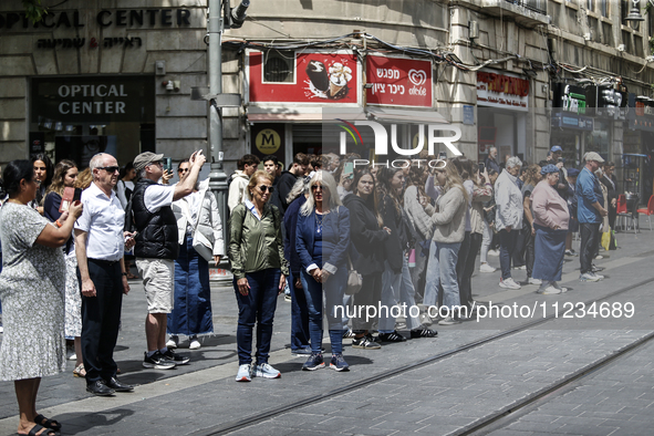 People are standing still as a siren sounds, marking Israel's Memorial Day, when the country commemorates fallen soldiers of Israel's wars a...