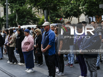 People are standing still as a siren sounds, marking Israel's Memorial Day, when the country commemorates fallen soldiers of Israel's wars a...