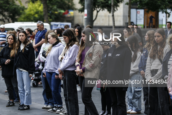 People are standing still as a siren sounds, marking Israel's Memorial Day, when the country commemorates fallen soldiers of Israel's wars a...