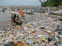 A number of fishing boats are on a beach full of rubbish, mostly plastics, in the Kwanyar district, Bangkalan, Madura Island, Indonesia, on...