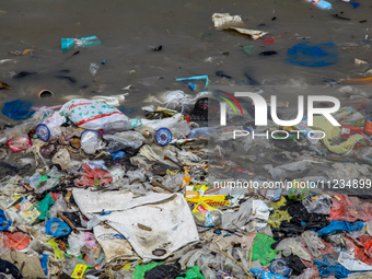 A number of fishing boats are on a beach full of rubbish, mostly plastics, in the Kwanyar district, Bangkalan, Madura Island, Indonesia, on...