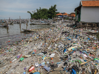 A number of fishing boats are on a beach full of rubbish, mostly plastics, in the Kwanyar district, Bangkalan, Madura Island, Indonesia, on...