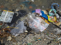 A number of fishing boats are on a beach full of rubbish, mostly plastics, in the Kwanyar district, Bangkalan, Madura Island, Indonesia, on...