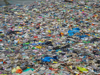 A number of fishing boats are on a beach full of rubbish, mostly plastics, in the Kwanyar district, Bangkalan, Madura Island, Indonesia, on...