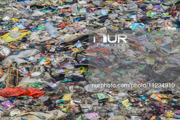 A number of fishing boats are on a beach full of rubbish, mostly plastics, in the Kwanyar district, Bangkalan, Madura Island, Indonesia, on...