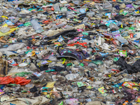 A number of fishing boats are on a beach full of rubbish, mostly plastics, in the Kwanyar district, Bangkalan, Madura Island, Indonesia, on...