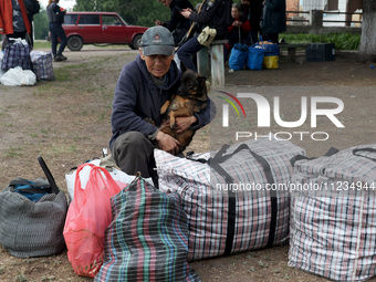 A man with a dog is evacuating from the city of Vovchansk, which is constantly subjected to Russian shelling, in the Kharkiv region, northea...