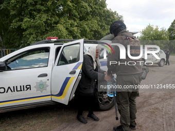 An officer is helping an elderly woman out of a police car during the evacuation of the civilian population from Vovchansk city, which is co...