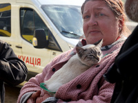 A woman with a cat is being seen during the evacuation of the civilian population from Vovchansk city, which is constantly subjected to Russ...