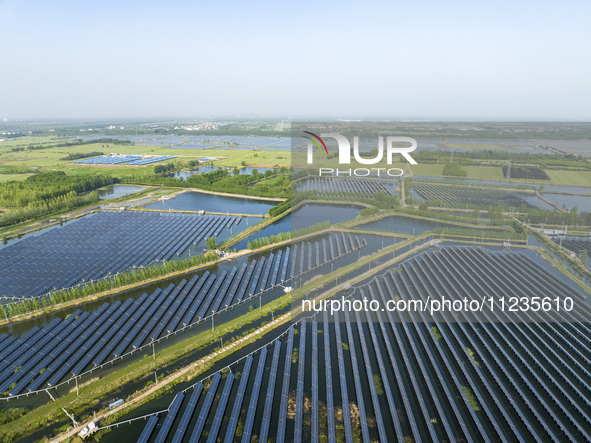 Photovoltaic panels are lining up in an ecological fish pond in Quyang town, Lianyungang, China, on May 13, 2024. 