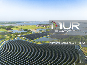 Photovoltaic panels are lining up in an ecological fish pond in Quyang town, Lianyungang, China, on May 13, 2024. (