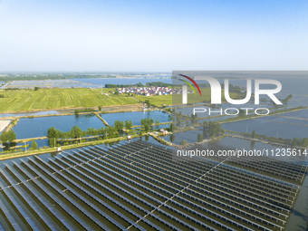 Photovoltaic panels are lining up in an ecological fish pond in Quyang town, Lianyungang, China, on May 13, 2024. (