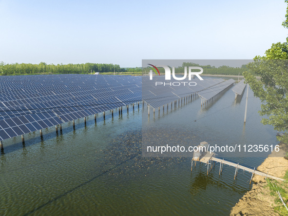 Photovoltaic panels are lining up in an ecological fish pond in Quyang town, Lianyungang, China, on May 13, 2024. 