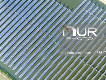 Photovoltaic panels are lining up in an ecological fish pond in Quyang town, Lianyungang, China, on May 13, 2024. (