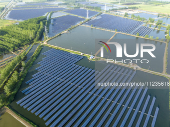 Photovoltaic panels are lining up in an ecological fish pond in Quyang town, Lianyungang, China, on May 13, 2024. (