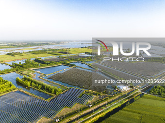 Photovoltaic panels are lining up in an ecological fish pond in Quyang town, Lianyungang, China, on May 13, 2024. (