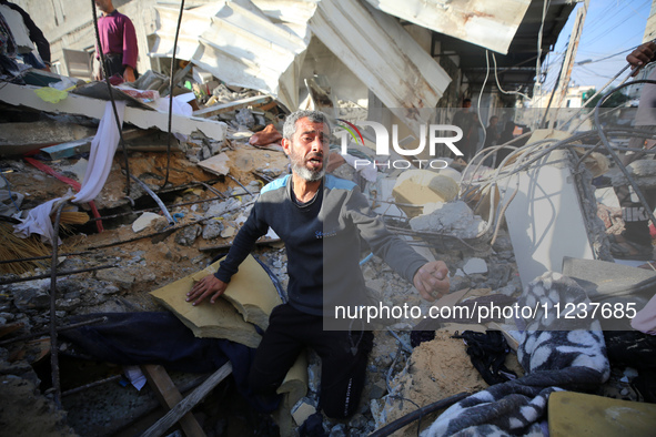 A Palestinian man is reacting as he searches for casualties at the site of an Israeli strike on a house, amid the ongoing conflict between I...