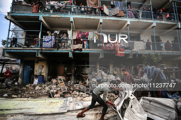 Palestinians are inspecting the site of an Israeli strike on a school sheltering displaced people, amid the ongoing conflict between Israel...