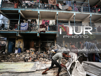 Palestinians are inspecting the site of an Israeli strike on a school sheltering displaced people, amid the ongoing conflict between Israel...