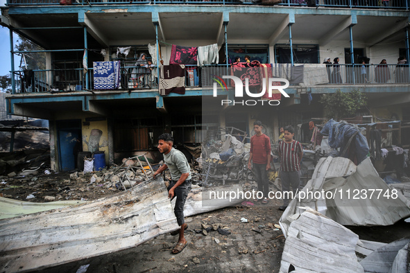 Palestinians are inspecting the site of an Israeli strike on a school sheltering displaced people, amid the ongoing conflict between Israel...