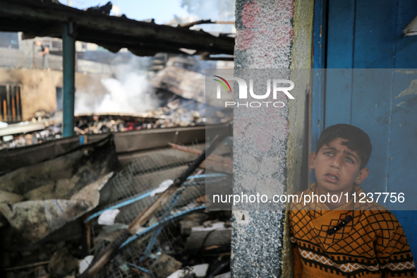 A Palestinian boy is inspecting the site of an Israeli strike on a school sheltering displaced people, amid the ongoing conflict between Isr...