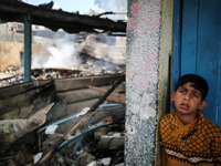 A Palestinian boy is inspecting the site of an Israeli strike on a school sheltering displaced people, amid the ongoing conflict between Isr...