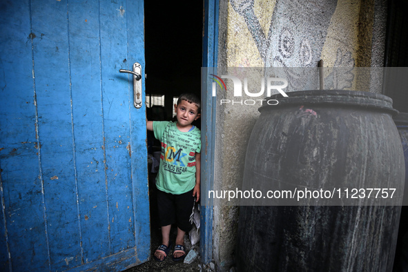 A Palestinian boy is inspecting the site of an Israeli strike on a school sheltering displaced people, amid the ongoing conflict between Isr...