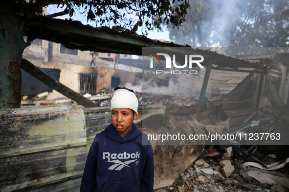 A Palestinian boy is inspecting the site of an Israeli strike on a school sheltering displaced people, amid the ongoing conflict between Isr...