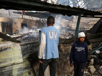 A Palestinian boy is inspecting the site of an Israeli strike on a school sheltering displaced people, amid the ongoing conflict between Isr...