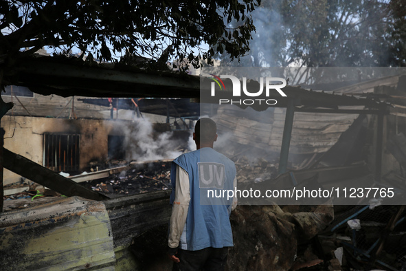 A Palestinian employee of UNRWA is looking at damages at the site of an Israeli strike on a school sheltering displaced people, amid the ong...