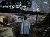 A Palestinian employee of UNRWA is looking at damages at the site of an Israeli strike on a school sheltering displaced people, amid the ong...