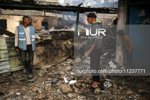 Palestinians are inspecting the site of an Israeli strike on a school sheltering displaced people, amid the ongoing conflict between Israel...