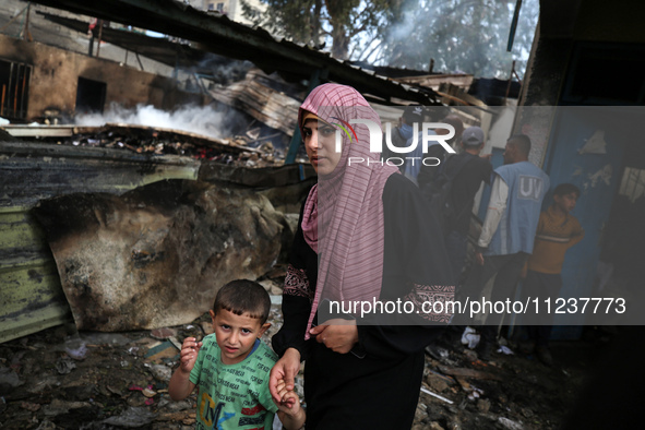 Palestinians are inspecting the site of an Israeli strike on a school sheltering displaced people, amid the ongoing conflict between Israel...