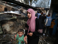 Palestinians are inspecting the site of an Israeli strike on a school sheltering displaced people, amid the ongoing conflict between Israel...