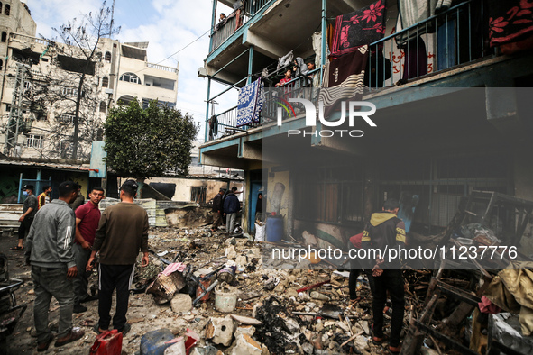 Palestinians are inspecting the site of an Israeli strike on a school sheltering displaced people, amid the ongoing conflict between Israel...