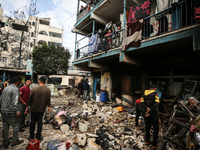 Palestinians are inspecting the site of an Israeli strike on a school sheltering displaced people, amid the ongoing conflict between Israel...