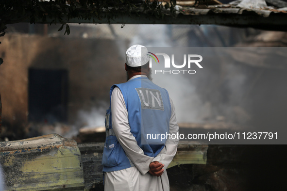 A Palestinian employee of UNRWA is looking at damages at the site of an Israeli strike on a school sheltering displaced people, amid the ong...