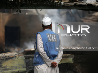 A Palestinian employee of UNRWA is looking at damages at the site of an Israeli strike on a school sheltering displaced people, amid the ong...