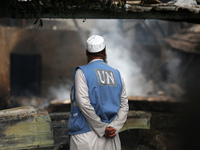 A Palestinian employee of UNRWA is looking at damages at the site of an Israeli strike on a school sheltering displaced people, amid the ong...