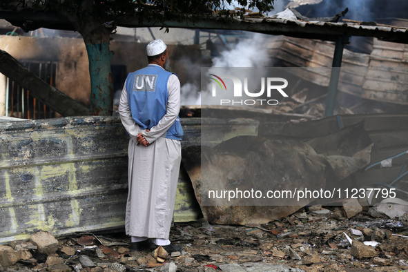 A Palestinian employee of UNRWA is looking at damages at the site of an Israeli strike on a school sheltering displaced people, amid the ong...