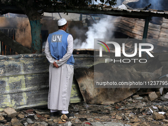 A Palestinian employee of UNRWA is looking at damages at the site of an Israeli strike on a school sheltering displaced people, amid the ong...