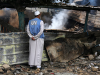 A Palestinian employee of UNRWA is looking at damages at the site of an Israeli strike on a school sheltering displaced people, amid the ong...