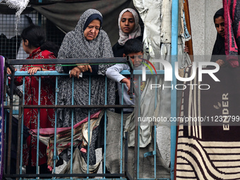 Palestinian women are looking on at the site of an Israeli strike on a school sheltering displaced people, amid the ongoing conflict between...