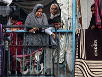 Palestinian women are looking on at the site of an Israeli strike on a school sheltering displaced people, amid the ongoing conflict between...