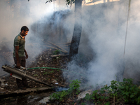 A worker is spraying pesticide to kill mosquitoes as a preventive measure against Dengue fever in a densely populated residential area in Dh...