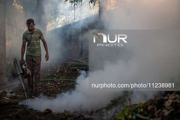 A worker is spraying pesticide to kill mosquitoes as a preventive measure against Dengue fever in a densely populated residential area in Dh...