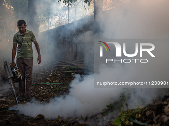 A worker is spraying pesticide to kill mosquitoes as a preventive measure against Dengue fever in a densely populated residential area in Dh...