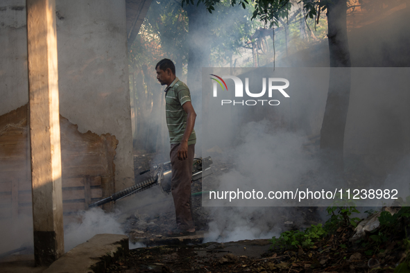 A worker is spraying pesticide to kill mosquitoes as a preventive measure against Dengue fever in a densely populated residential area in Dh...