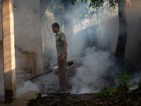 A worker is spraying pesticide to kill mosquitoes as a preventive measure against Dengue fever in a densely populated residential area in Dh...